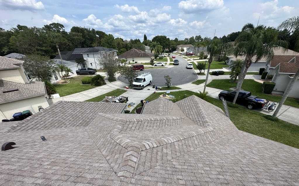Illustrative view across a shingle roof toward a residential neighborhood